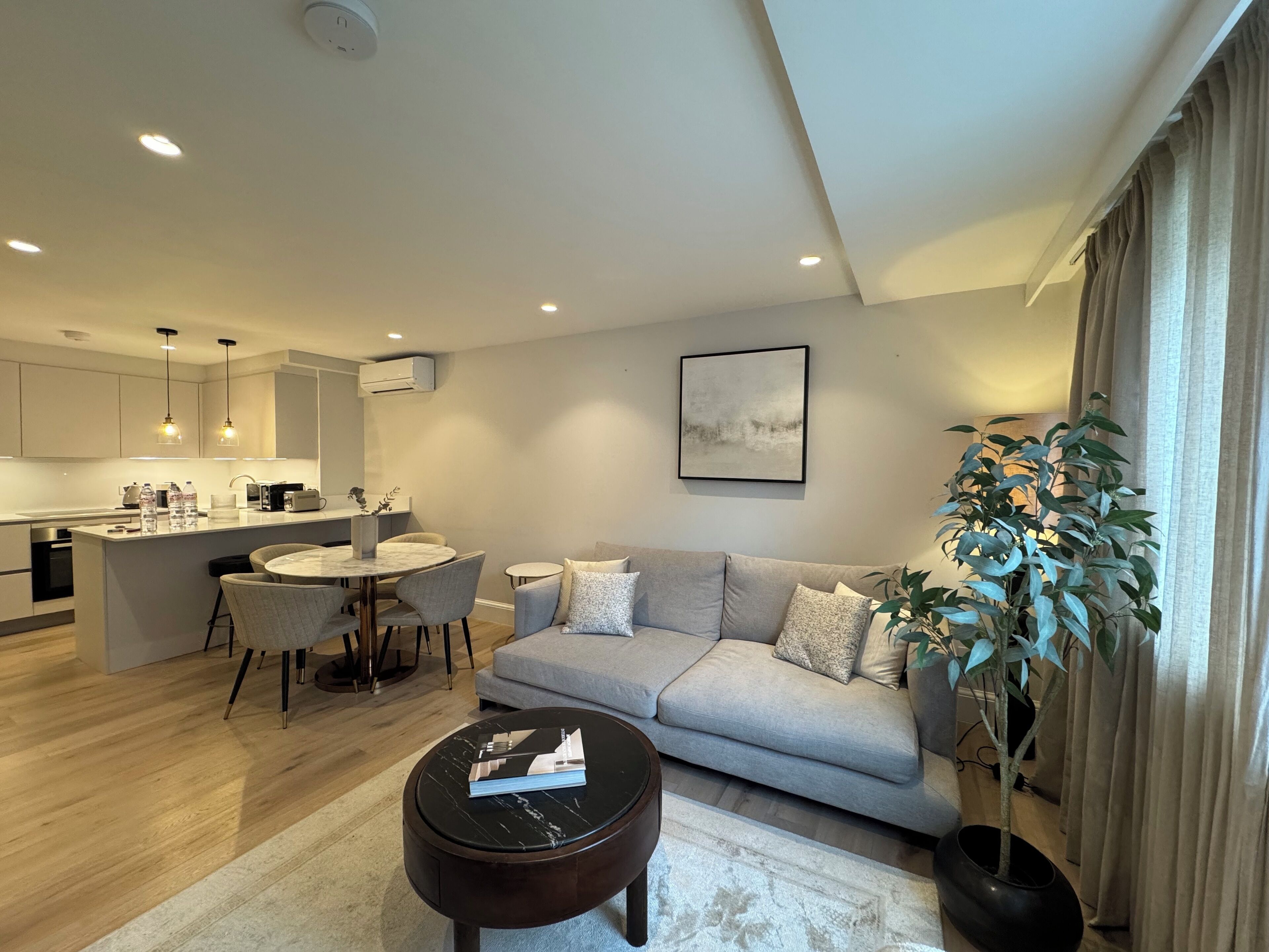 Un salon moderne avec un canapé, une table basse et un coin repas.
