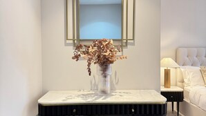 Une chambre à coucher moderne avec un lit, des tables de chevet et un miroir décoratif au mur.