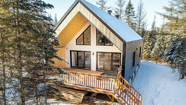 A cabin with a wooden deck and a staircase leading to the entrance. - Spa - Pool table | Great Comfort | Chalet Le Mysa (Shannon)