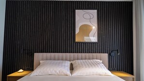 A modern hotel room with a large bed, two bedside tables, and a wall-mounted artwork. - Pied-à-terre (Zadar)