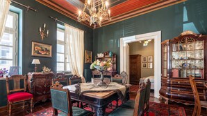 A traditional room with a wooden table, chairs, a chandelier, and a large cabinet with glass doors.