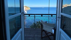 A balcony with a view of the sea and a distant island.