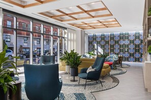 A modern lobby with a high ceiling, large windows, and a patterned wall. - Spacious Apt with Kitchen in Fenway (Boston, MA)