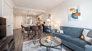 A modern apartment with a living room, dining area, and kitchen. - Luxury Modern Apt with Pool (Stamford, CT)