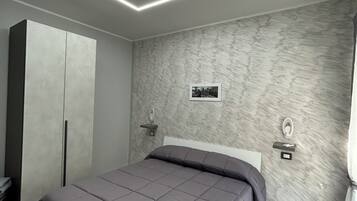 Un dormitorio moderno con cama, armario e iluminación empotrada.