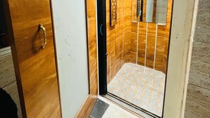Een lift met houten lambrisering en een betegelde vloer.
