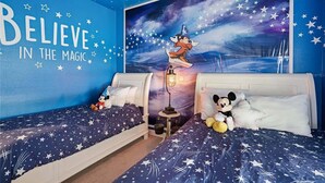 A bedroom with two beds, star-patterned bedding, a large wall mural, and a motivational quote. - Themed 5Bd Paradise Palms Close to Disney w Pool 8951 (Kissimmee)