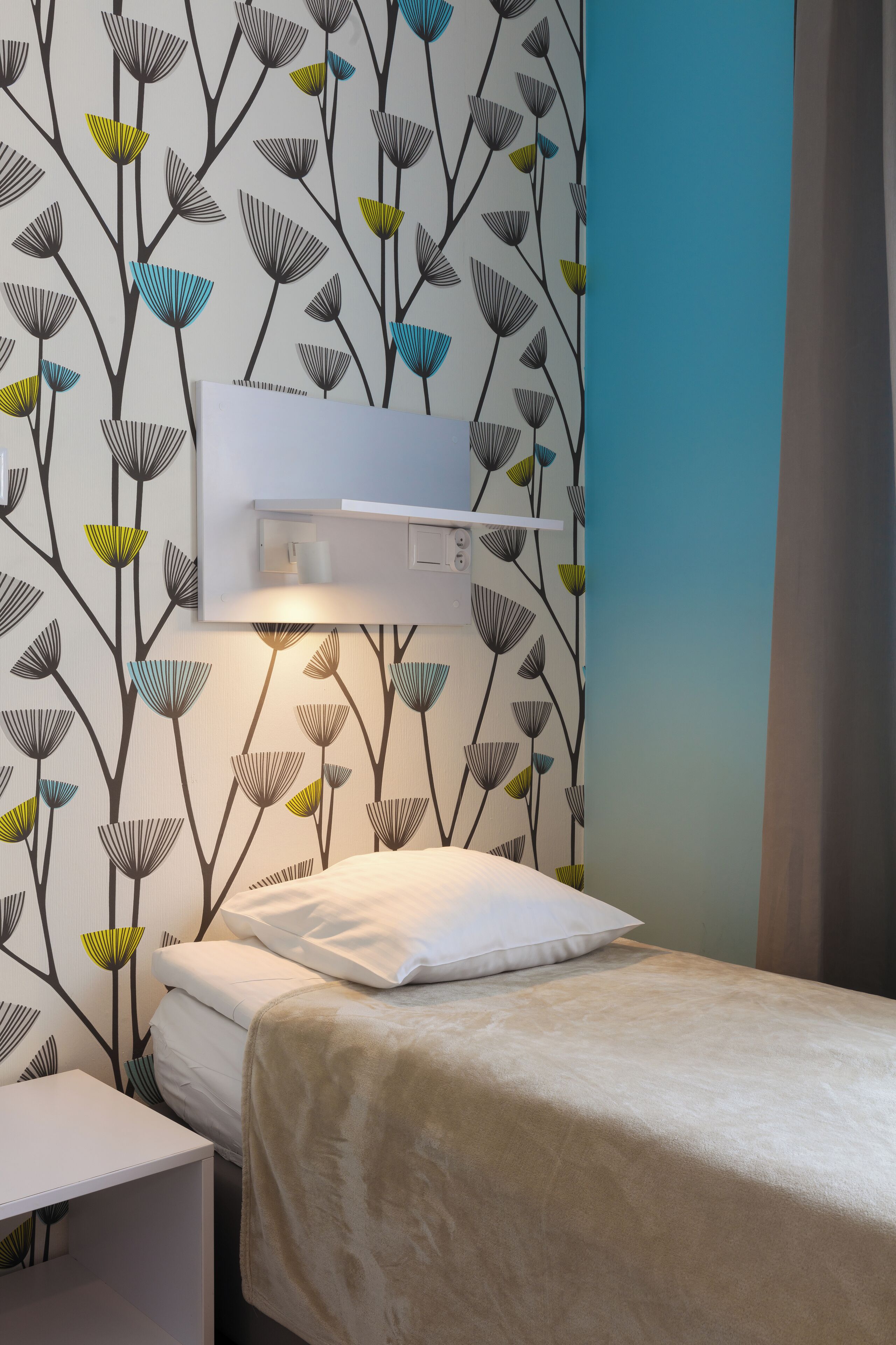 A bedroom with a bed, a nightstand, and a wall-mounted air conditioning unit.