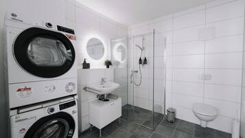 Chuveiro, secador de cabelo, toalhas de banho, papel higiênico