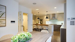 A modern kitchen with white cabinets, a central island, and pendant lighting.