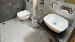Een moderne badkamer met een douche, toilet en wastafel.