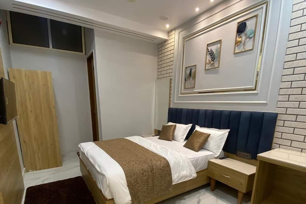Une chambre moderne avec un grand lit, des tables de chevet, un ventilateur de plafond et un sol en marbre.