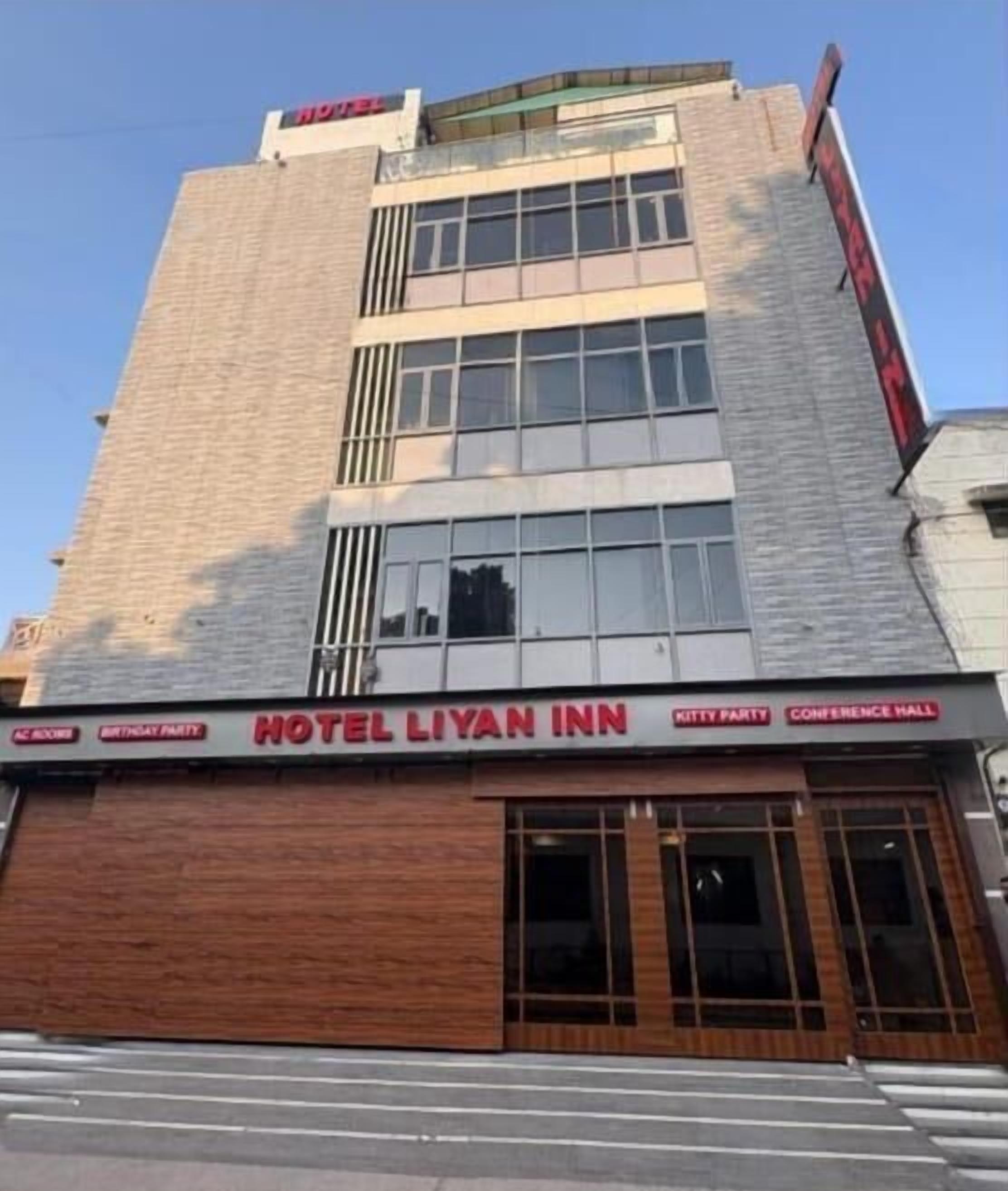 Ein Hotel mit einem Schild, auf dem „HOTEL LIYAN INN“ steht und „KITTY PARTY“ sowie „KONFERENZSAAL“ erwähnt.