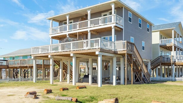 A multi-story beachfront property with balconies, outdoor seating, and a covered patio area. - Surfside Beach Getaway Steps from the Ocean (Surfside Beach)