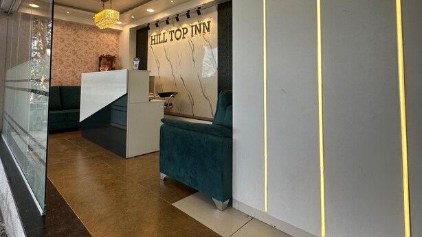 Eine moderne Hotelhalle mit Empfangstresen, einer Kristallleuchter und einer Sitzecke.
