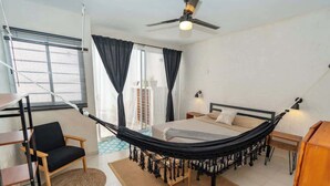 A bedroom with a bed, a hammock, a chair, a desk, and a ceiling fan. - Charming Tulum House with Private Pool and Bikes (Tulum)