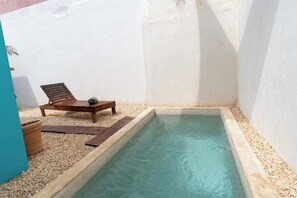A small pool with a wooden lounge chair and a potted plant. - Central Tulum House: Private Pool & Bikes (Tulum)