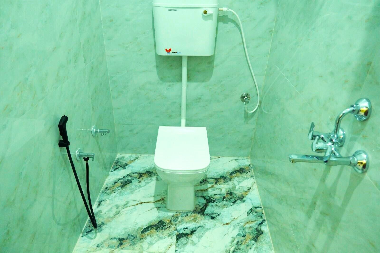 A bathroom with a toilet, a shower, and a sink.