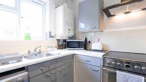 A modern kitchen with stainless steel appliances, a built-in oven, and a microwave. - House-sleeps7-parking-garden-petfriendly (Leeds)