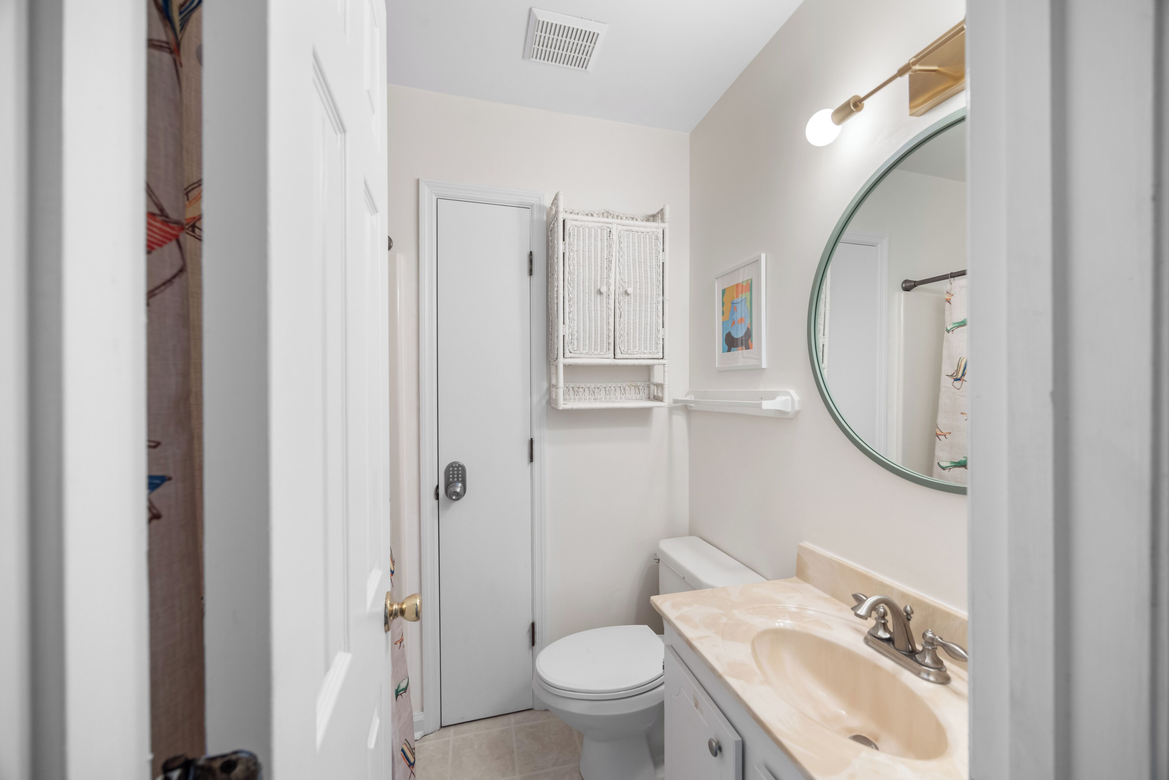 Une petite salle de bain comprenant des toilettes, un lavabo et un petit meuble de rangement.