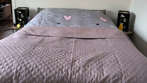Ein Schlafzimmer mit einem Bett, einem Wandbild und zwei Nachttischen mit Lampen.