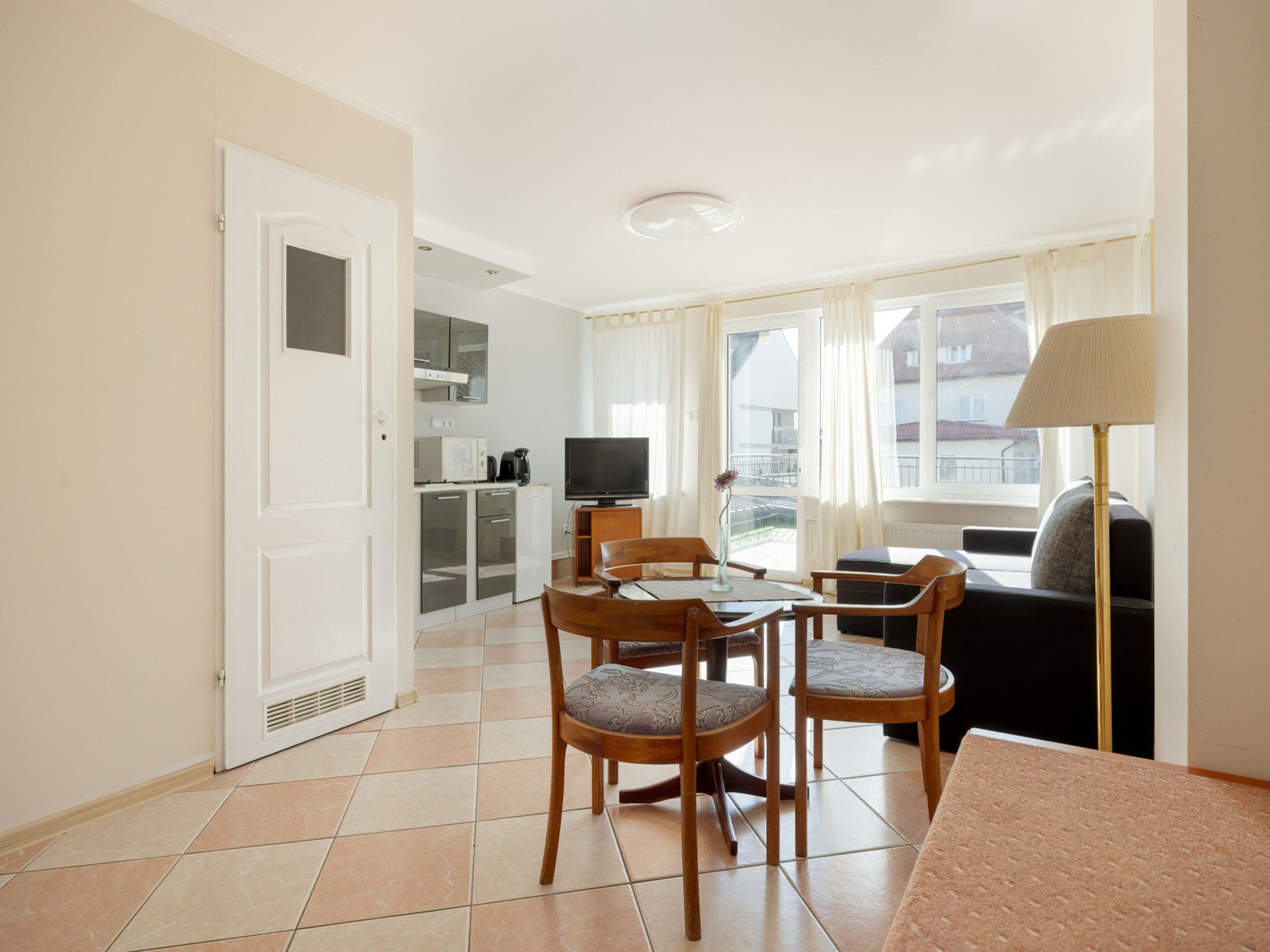 Un espace de vie compact comprenant un coin repas, une kitchenette et un coin salon.