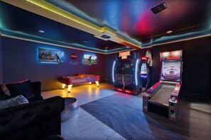 A room with a pool table, arcade games, and a couch. - Luxury Villa near Disney: Arcade, Theater, & more! (Kissimmee)