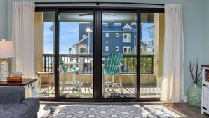A room with a sliding glass door leading to a balcony with outdoor furniture. - ☀️Full Beach View, Pool, Hot tub, Club at MXB 1K-Forgotten Cove☀️ (Mexico Beach)