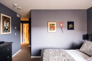 A bedroom with a bed, a dresser, and a hallway leading to another room. - Choice Condo | Walk to Gondola | Sleeps 7! (Avon)
