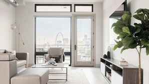 A modern living room with a sofa, coffee table, and a large plant.