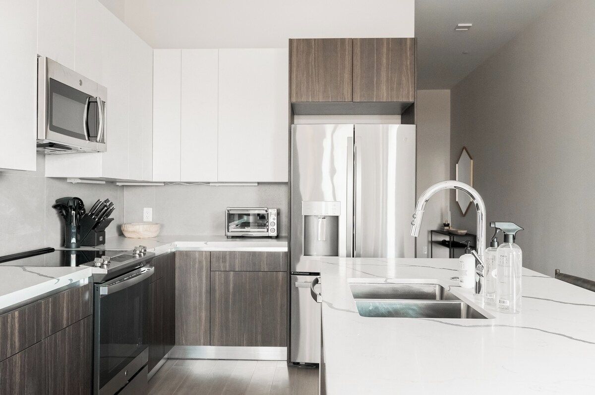 A modern kitchen with a built-in oven, microwave, and refrigerator.