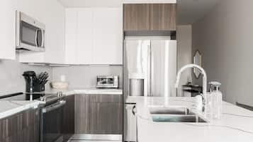 A modern kitchen with a built-in oven, microwave, and refrigerator.