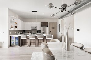 Une cuisine moderne dotée d’un îlot central, de tabourets de bar et d’une table à manger avec des chaises.