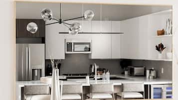 A modern kitchen with a central island, stainless steel appliances, and a pendant light with multiple bulbs.