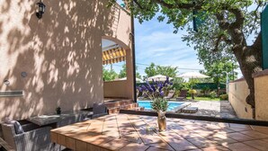 An outdoor patio area with a pool, wicker furniture, and a vase with flowers. - Villa Oaza - private pool, fitness, near a park forest (Pula)