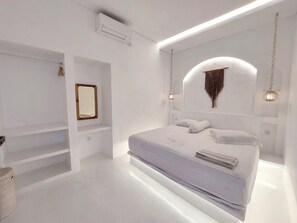 A modern bedroom with a large bed, built-in shelving, and pendant lighting. - Double D Guesthouse and Villa (Kerobokan)