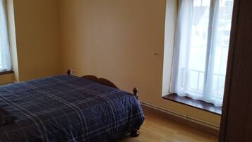 Una camera da letto con un letto, una finestra e una lampada a sospensione.