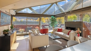 A spacious living area with a large window offering a mountain view, a fireplace, and modern furniture. - Spritz House- 4 Level Telluride Luxury with Penthouse (Telluride)