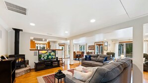 A modern living room with a fireplace, a television, and a large grey sofa. - Pet Friendly Cottage in Egg Harbor-Close to Beach (Egg Harbor)