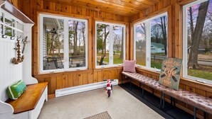 A wooden cabin with large windows, a bench, and a small motorcycle. - Pet Friendly Cottage in Egg Harbor-Close to Beach (Egg Harbor)