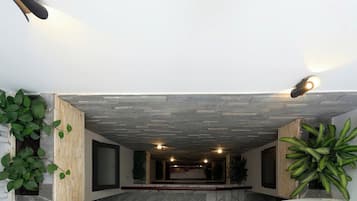 Un interior espacioso con techo alto, iluminación empotrada y suelo de mármol.
