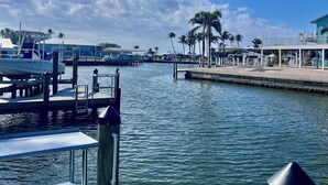 A marina with docked boats, a wooden pier, and a clear blue sky.