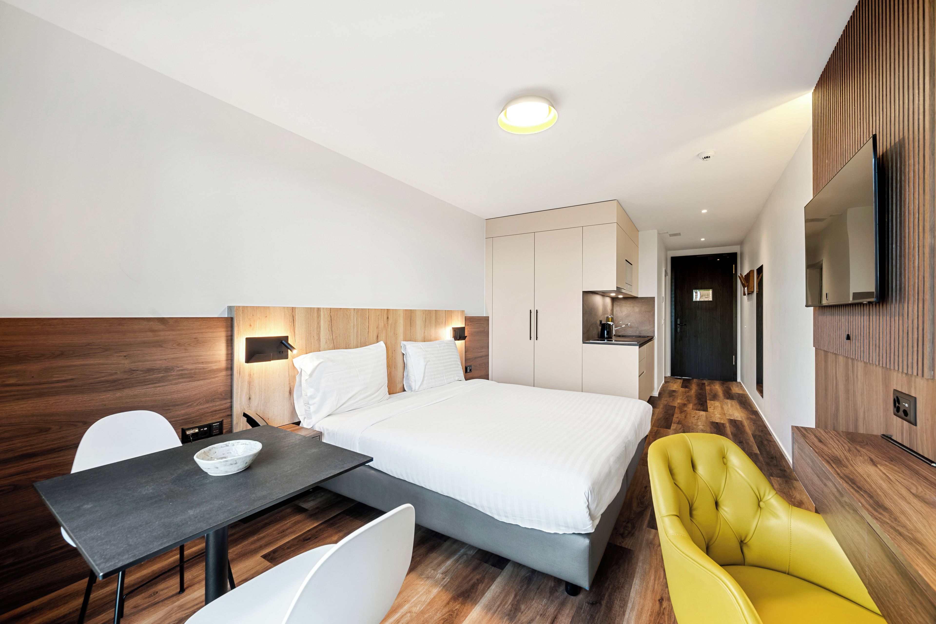 Een hotelkamer met een bed, bureau, stoel en televisie.