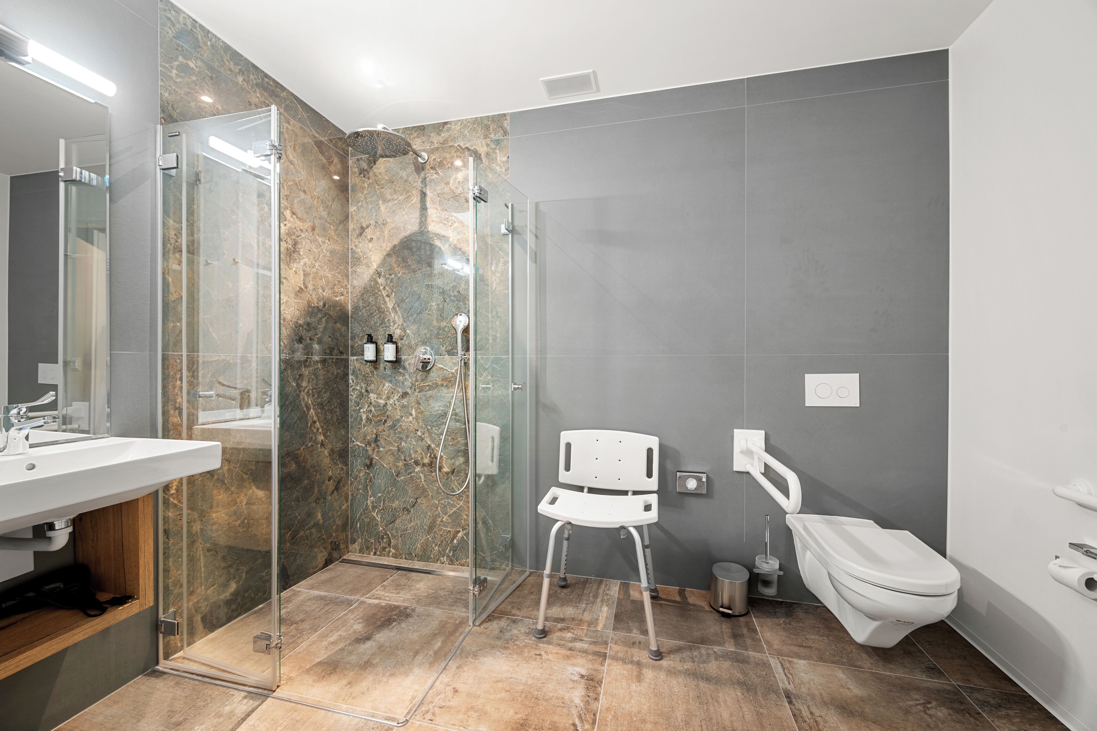 Une salle de bain moderne avec une douche à parois de verre, des toilettes blanches et un lavabo.