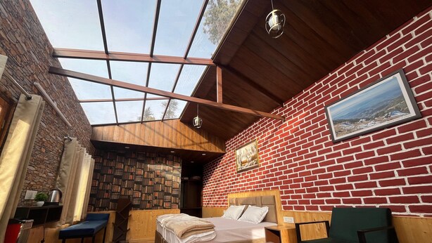 Una habitación acogedora con una cama, un escritorio, una silla y un ventanal grande.