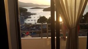 A room with a large window overlooking a body of water and a distant landscape.