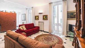 A modern living room with a red sofa, a brown sofa, a patterned rug, and a television. - Palmaria suite, charming 1 bedroom apartment in delightful Genova with AC, WIFII (Genova)