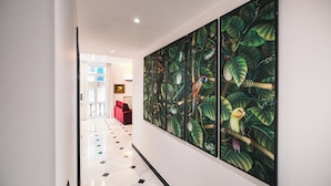 A hallway with a large, vibrant mural of birds and foliage on the wall. - Palmaria suite, charming 1 bedroom apartment in delightful Genova with AC, WIFII (Genova)