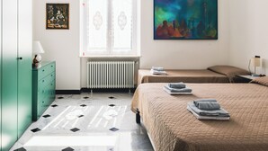 A hotel room with a bed, a dresser, a radiator, a window, and a painting on the wall. - Palmaria suite, charming 1 bedroom apartment in delightful Genova with AC, WIFII (Genova)