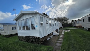 A mobile home with a porch and a small garden area. - Heidi 2 Bed Robin Hood (Rhyl)